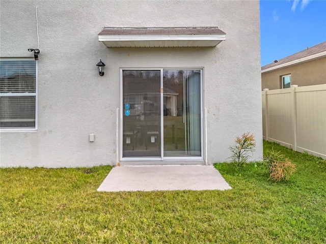 property entrance with a lawn