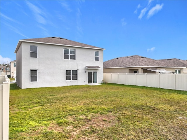 back of house with a lawn