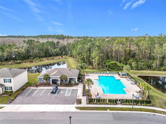 view of pool featuring a patio and a water view