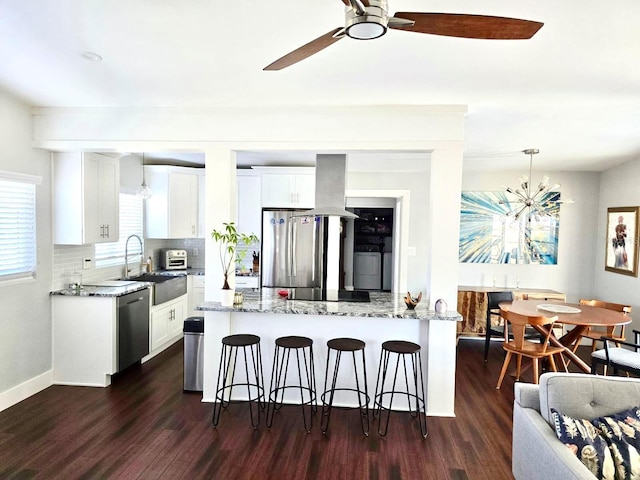 kitchen with stainless steel appliances, white cabinetry, sink, and pendant lighting