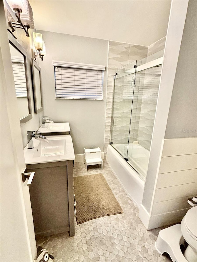 full bathroom with vanity, tile patterned floors, toilet, and combined bath / shower with glass door