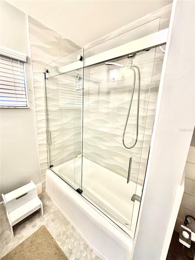 bathroom featuring tile patterned flooring and combined bath / shower with glass door