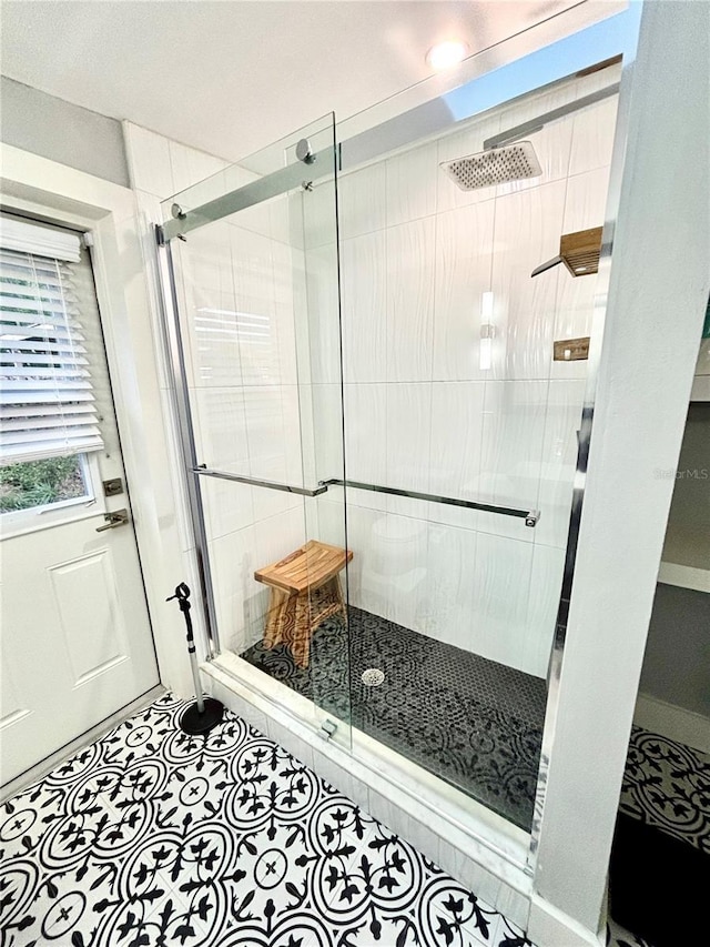 bathroom with tile patterned flooring and walk in shower