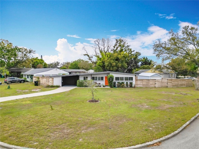 view of front of home with a front lawn, fence, driveway, and a carport