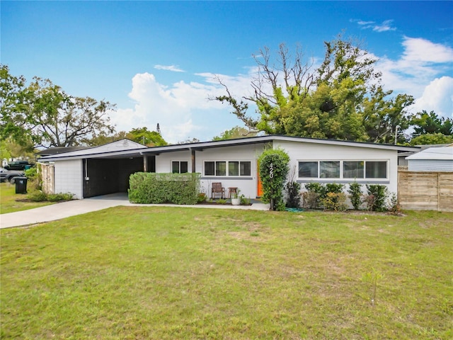 mid-century modern home with a carport, a front yard, driveway, and fence