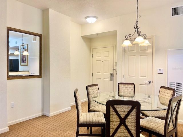 carpeted dining space with a textured ceiling and a notable chandelier