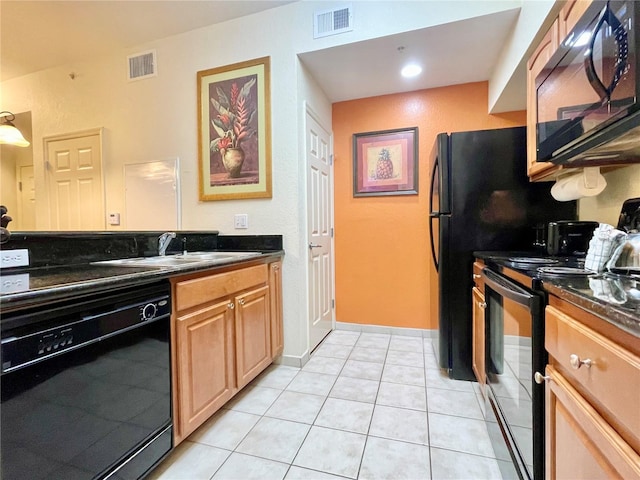 kitchen featuring light tile patterned flooring, dark stone counters, sink, and black appliances