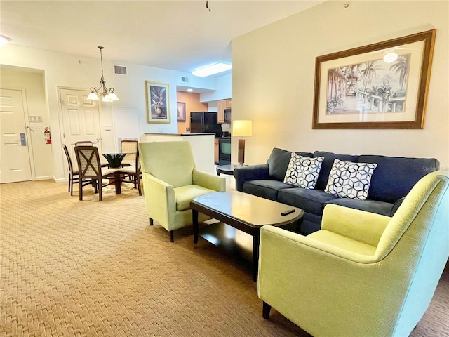 living room with carpet and a notable chandelier