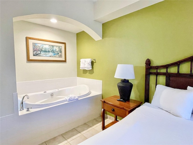 bathroom featuring a relaxing tiled tub and tile patterned flooring