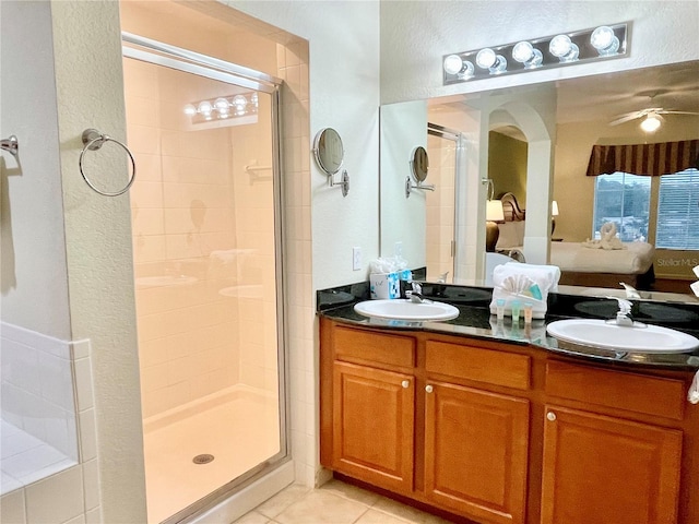 bathroom featuring tile patterned flooring, vanity, ceiling fan, and walk in shower