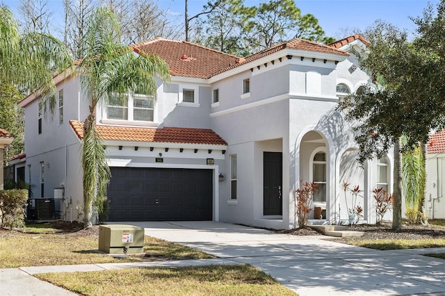 mediterranean / spanish-style home with a garage and central AC