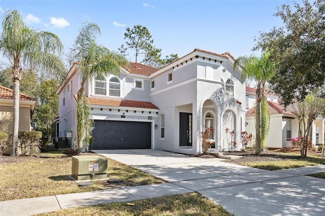 mediterranean / spanish home featuring a garage and central AC unit