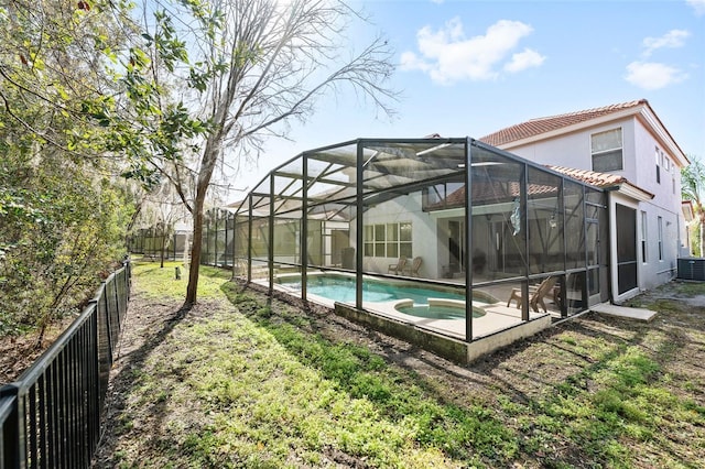 back of property featuring a lanai, a fenced in pool, a lawn, and a patio