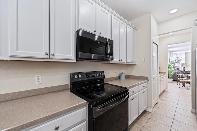 kitchen featuring white cabinetry, light tile patterned floors, and black range with electric cooktop