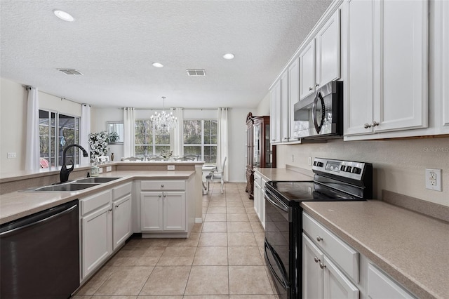 kitchen with sink, black appliances, white cabinetry, and a textured ceiling