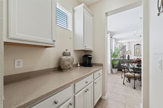 kitchen with light tile patterned floors and white cabinets