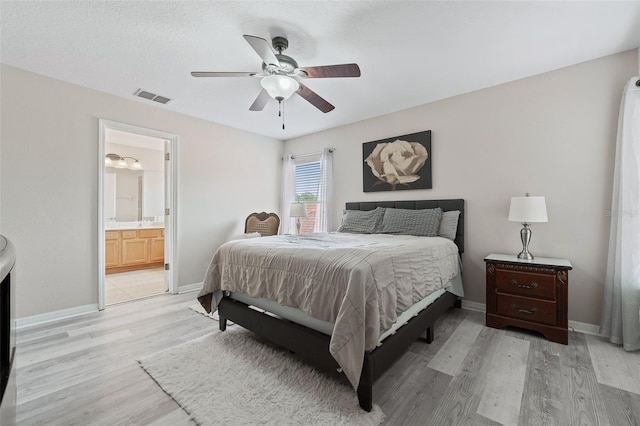 bedroom with light hardwood / wood-style flooring, ensuite bath, and ceiling fan