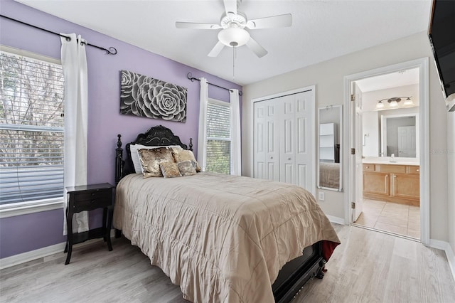 bedroom with a closet, ceiling fan, light hardwood / wood-style floors, and ensuite bath