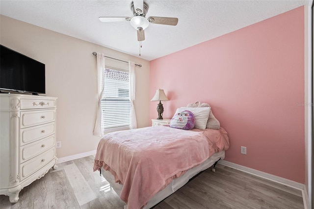 bedroom featuring light wood-type flooring, a textured ceiling, and ceiling fan