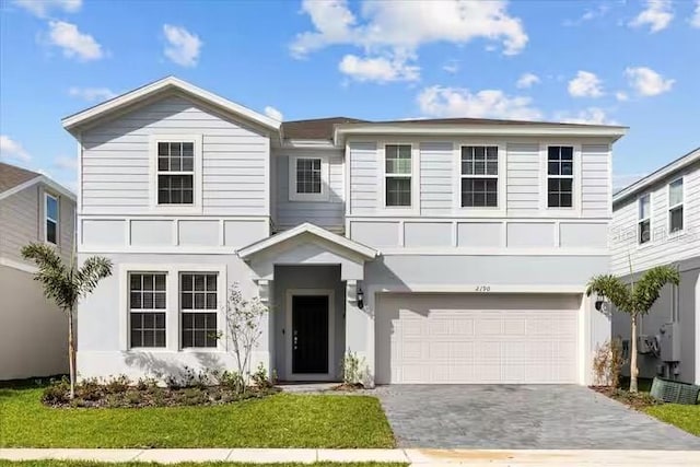 view of front of property with a garage and a front lawn