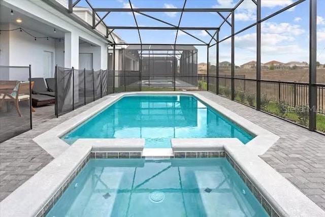 view of swimming pool with a lanai, a patio, and an in ground hot tub