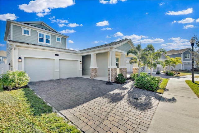 view of front of home with stone siding, decorative driveway, an attached garage, and stucco siding