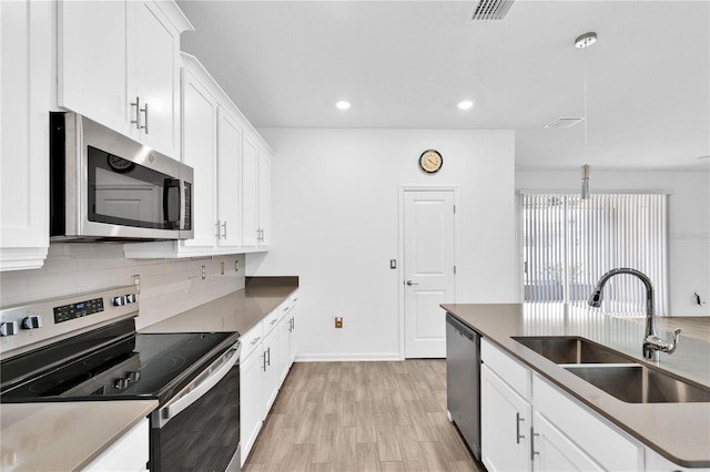 kitchen featuring tasteful backsplash, appliances with stainless steel finishes, sink, and white cabinets