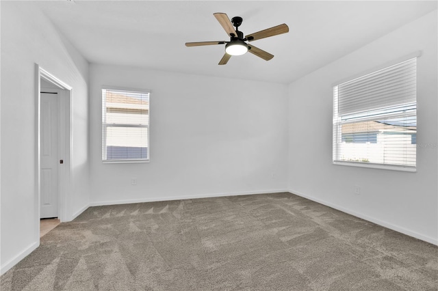 carpeted empty room featuring ceiling fan and a healthy amount of sunlight