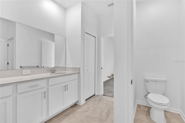 bathroom with tile patterned flooring, vanity, and toilet