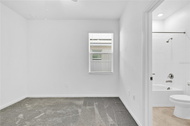 full bathroom featuring toilet, baseboards, and tub / shower combination