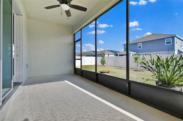 unfurnished sunroom featuring ceiling fan