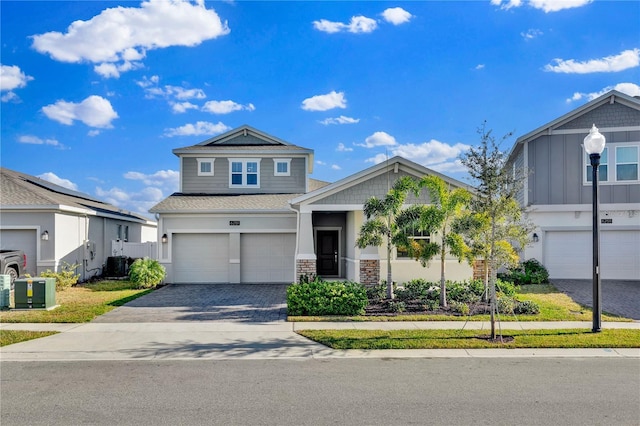 view of front of home featuring decorative driveway, an attached garage, cooling unit, and stucco siding