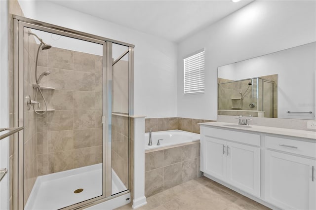 bathroom featuring a stall shower, a garden tub, vanity, and tile patterned floors