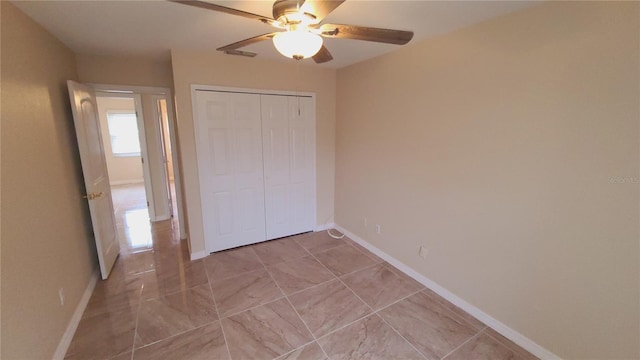 unfurnished bedroom featuring ceiling fan and a closet