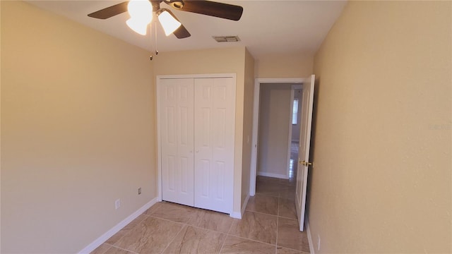 unfurnished bedroom with ceiling fan and a closet