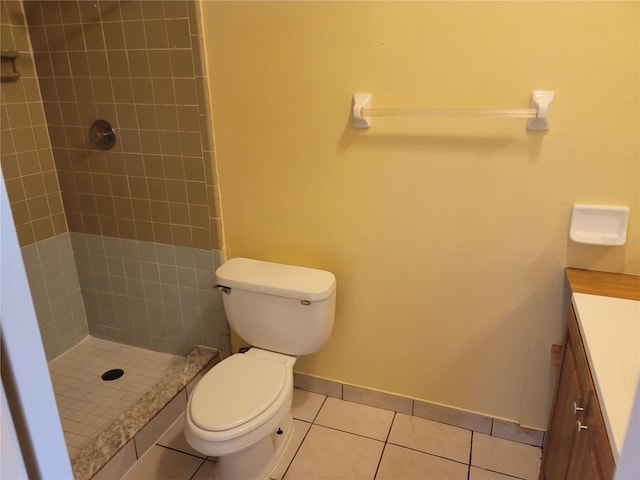 bathroom featuring tile patterned floors, vanity, a tile shower, and toilet