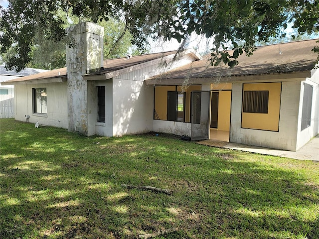 back of property featuring a lawn