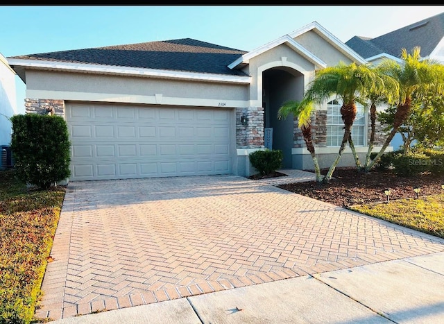 view of front facade with a garage and central AC