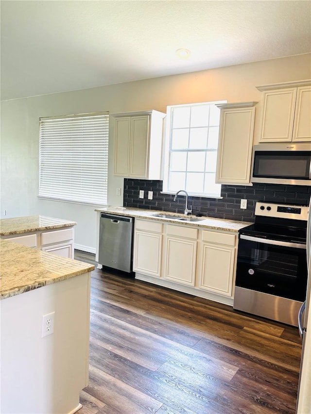 2304 Cedar Garden Dr, Orlando, FL 32824 - kitchen with stainless steel appliances, a sink, backsplash, dark wood-style flooring, and light stone counters