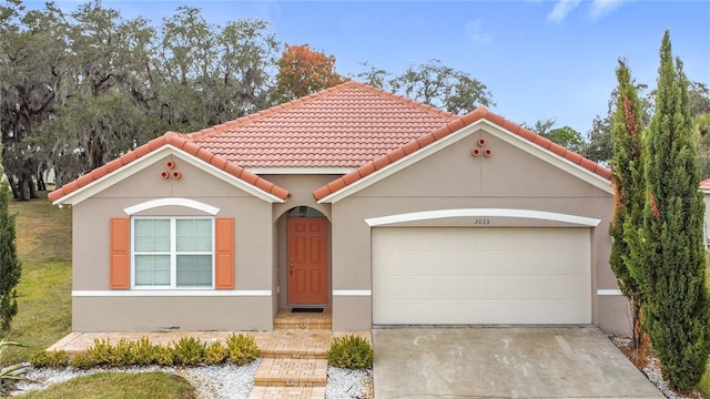 mediterranean / spanish-style home with a garage