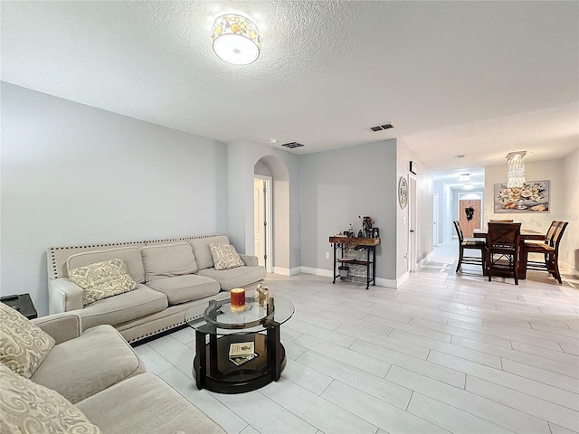 living room with a textured ceiling and light wood-type flooring