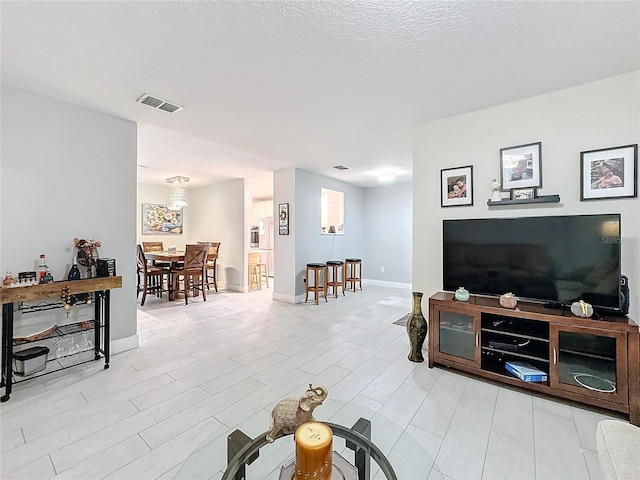 living room with light hardwood / wood-style flooring and a textured ceiling