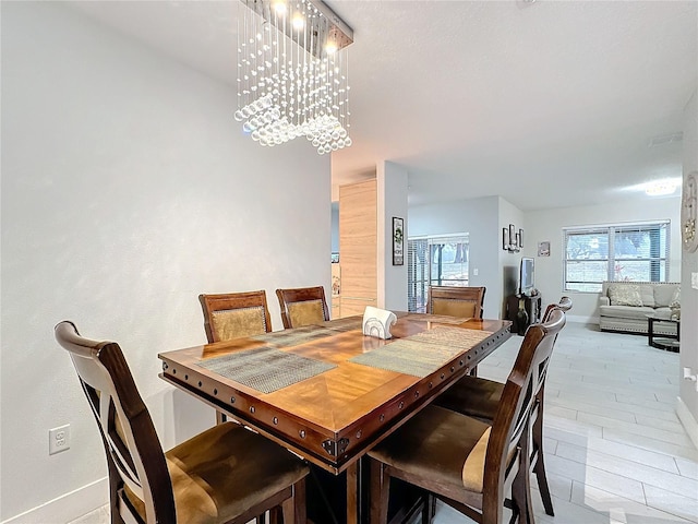 dining area featuring a notable chandelier and light hardwood / wood-style floors