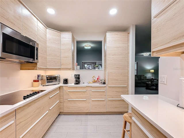 kitchen featuring electric stovetop and light brown cabinetry