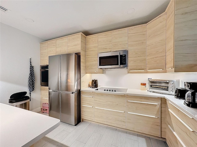 kitchen featuring light brown cabinetry and appliances with stainless steel finishes