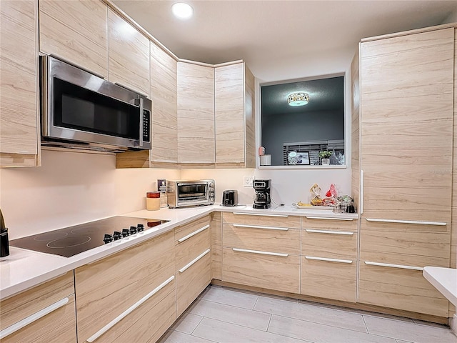 kitchen with black electric cooktop and light brown cabinets