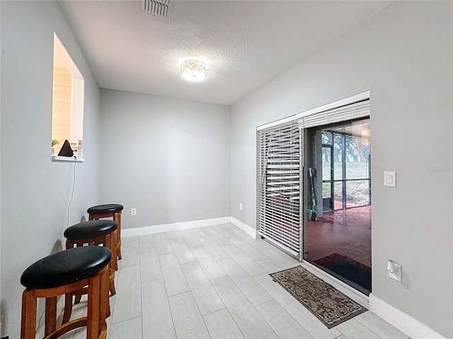 interior space with light hardwood / wood-style floors and a textured ceiling