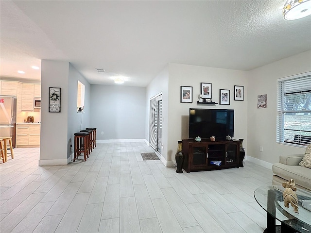 living room featuring a textured ceiling and light wood-type flooring