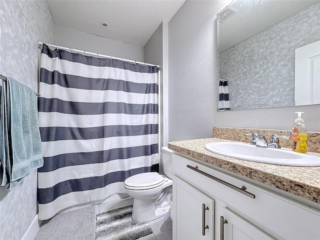 bathroom with vanity, curtained shower, toilet, and a textured ceiling