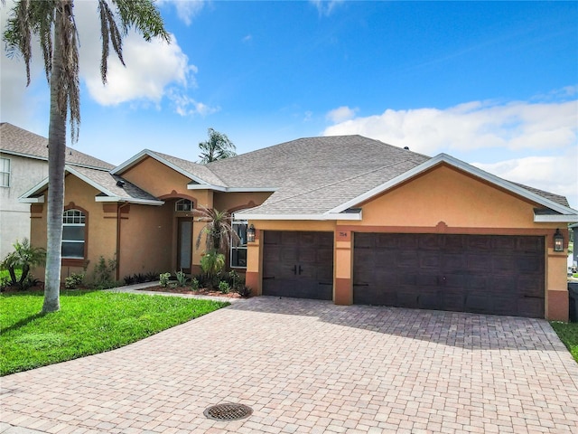 ranch-style house with a garage and a front lawn